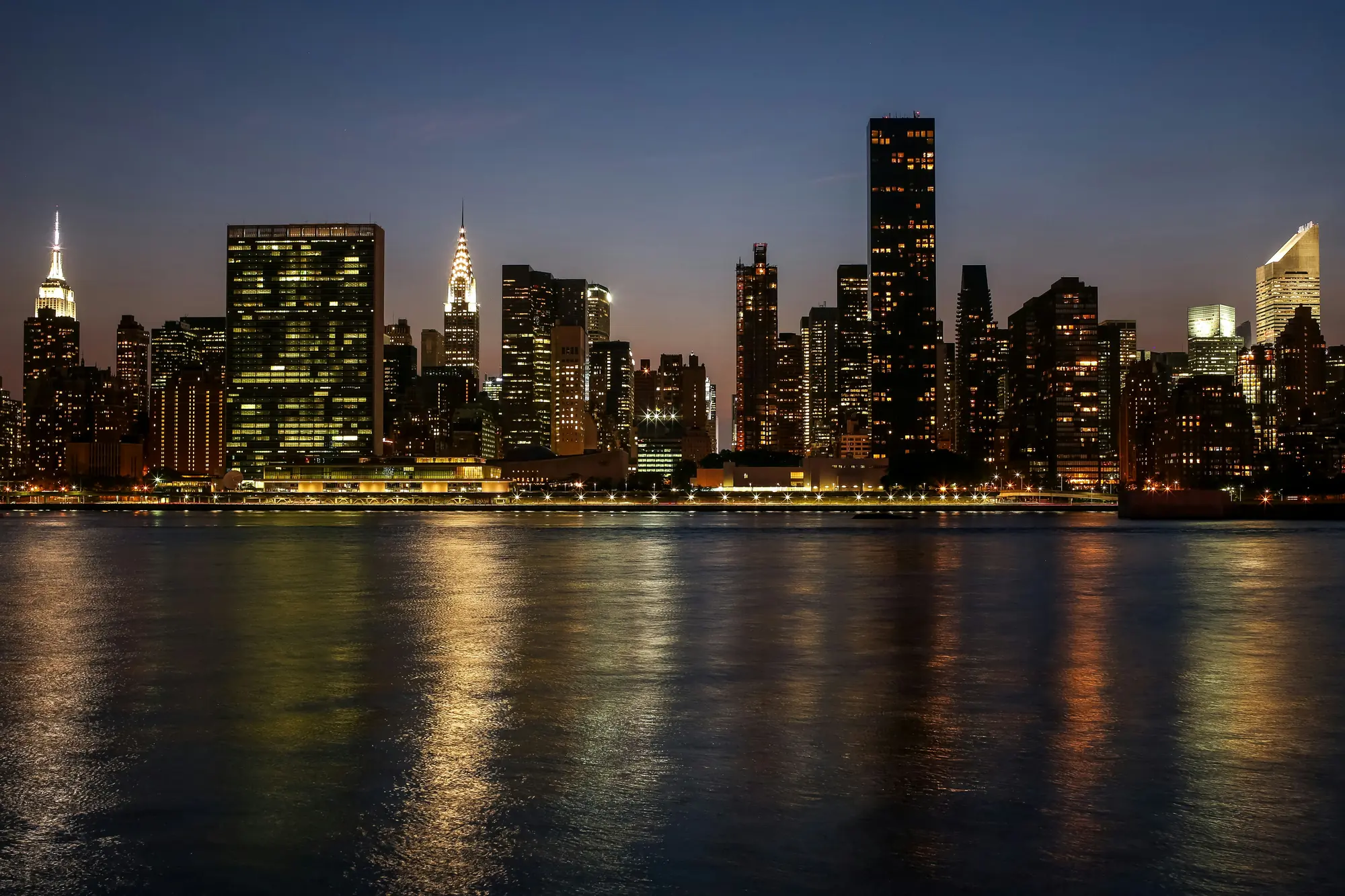 A city skyline at dusk across the water